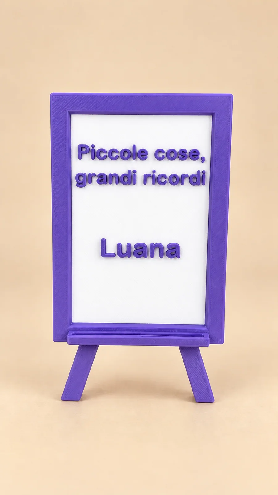 Segnaposto su cavalletto viola con pannello bianco, frase Piccole cose, grandi ricordi e nome Luana, su sfondo beige