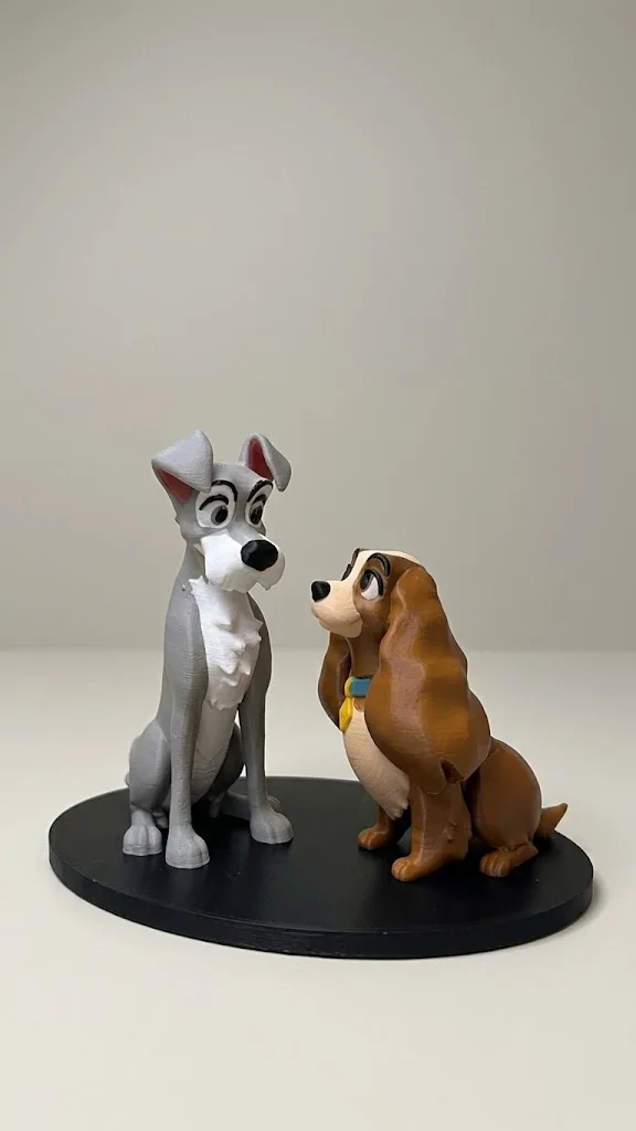 Statuine di Lilli e il Vagabondo su base ovale nera, su sfondo neutro