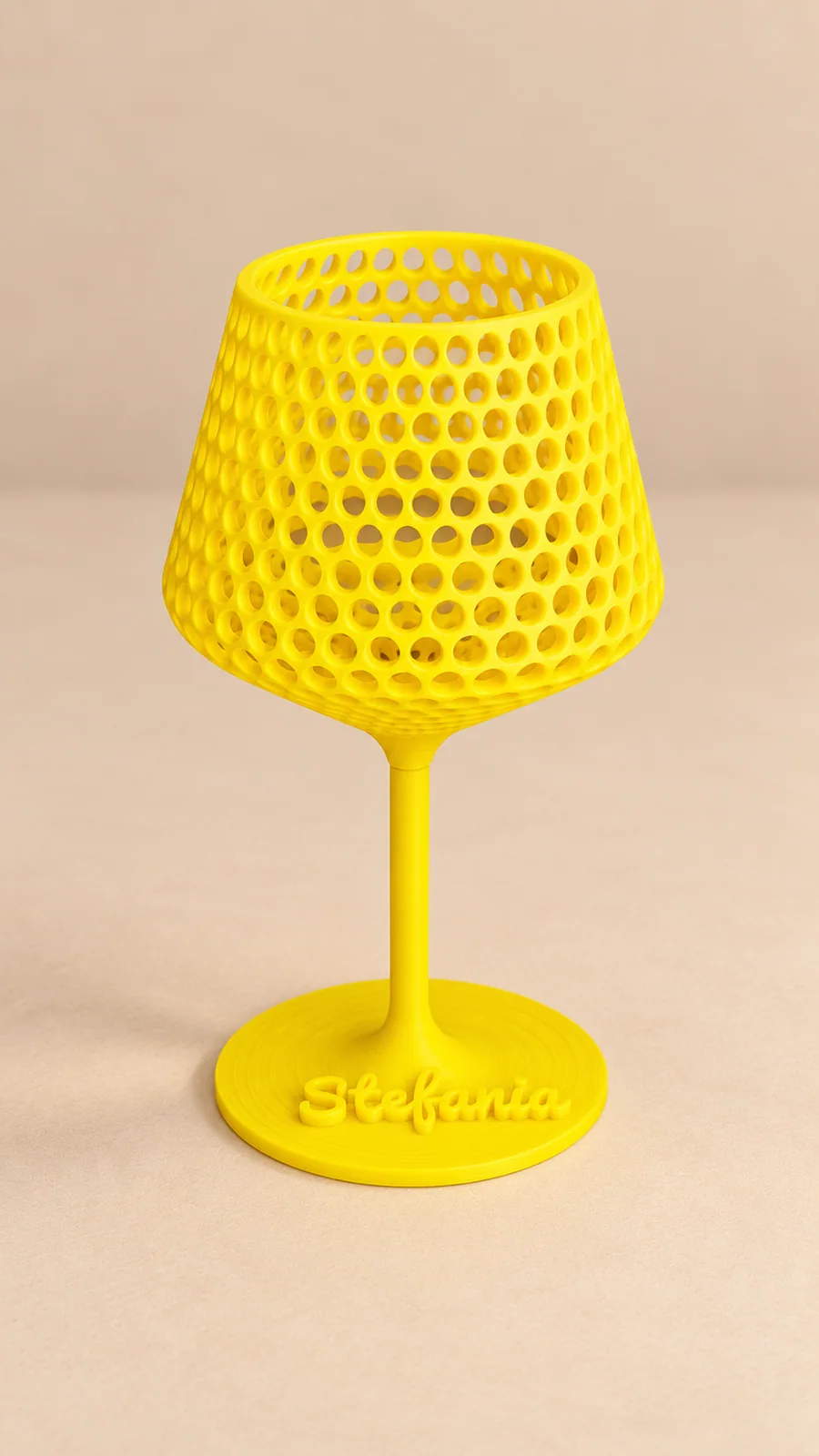 Calice giallo traforato con il nome Stefania in rilievo sulla base, su sfondo beige neutro